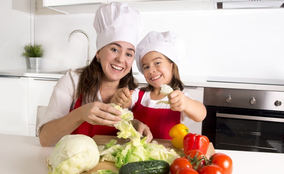 Mother and child learning to cook salad at home